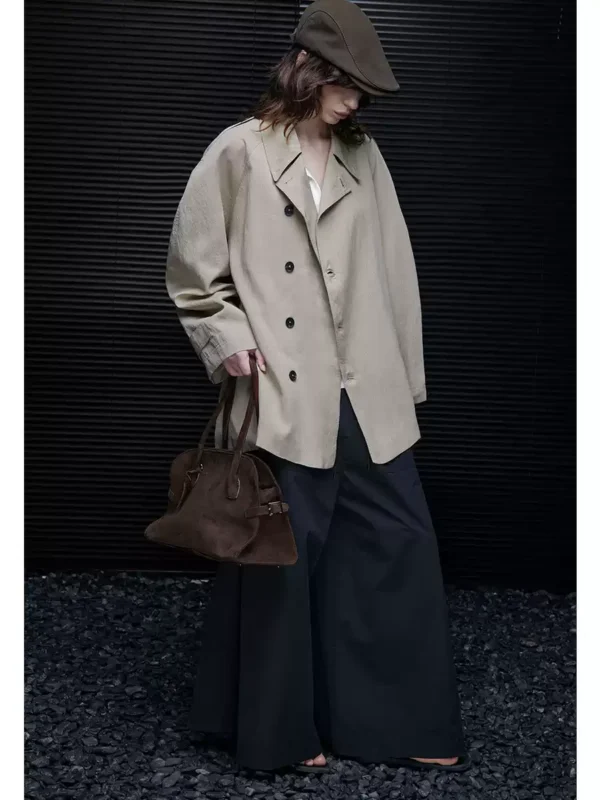 A woman wearing a light khaki windbreaker - Image 3