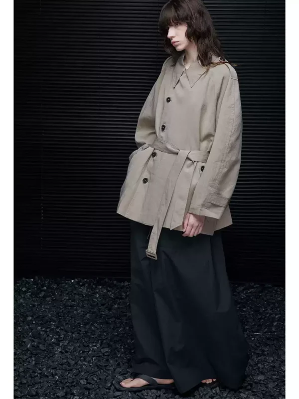 A woman wearing a light khaki windbreaker - Image 2