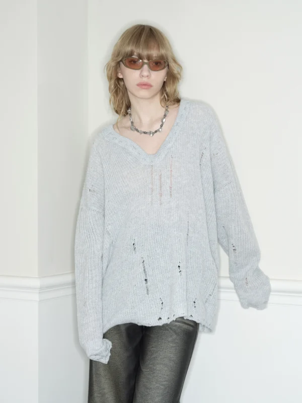 A woman in a laid-back grey heart-neck sweater - Image 2